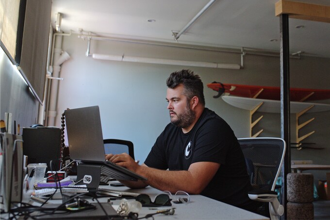 Small business owner on his desk working using a laptop