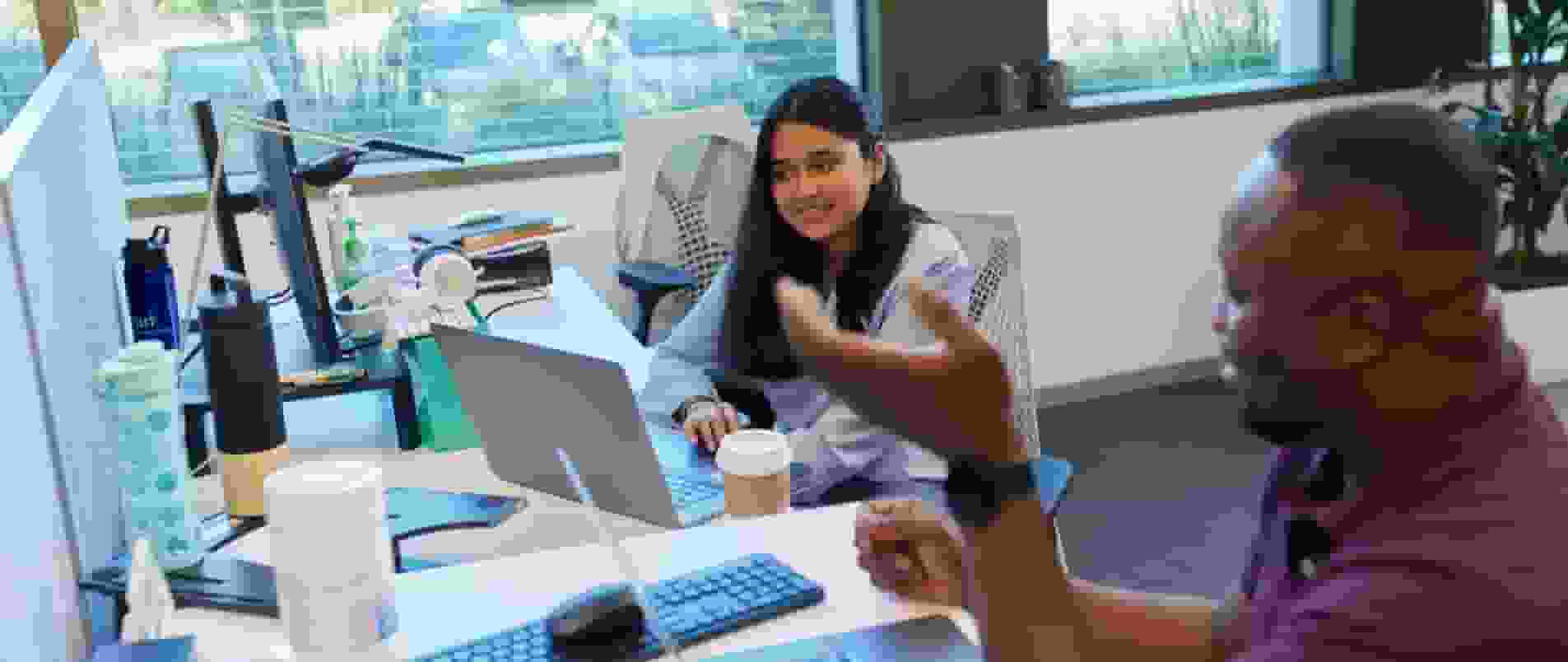 A person sitting at a table with a laptop computer.