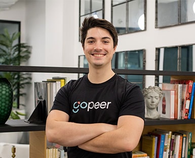 A man smiling for the camera with a bookshelf behind