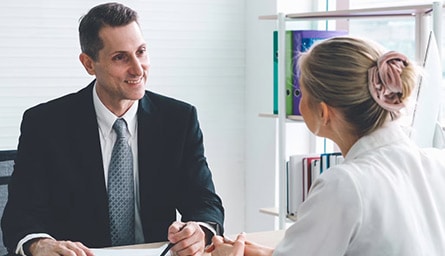 A person in a suit talking to a person in a white dress.