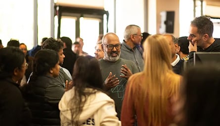 A crowd of people standing around a room.