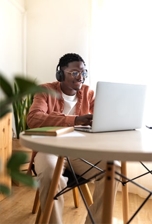 A person sitting at a desk with a laptop computer.