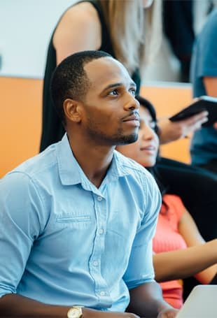 A person sitting down looking at his cell phone.