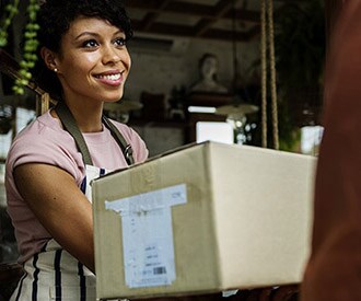 a woman at her business happily receiving a package