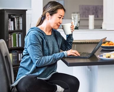 tax-preparer-laptop-photo-icom-desktop-386x312.jpeg A person sitting at a desk with a laptop computer.