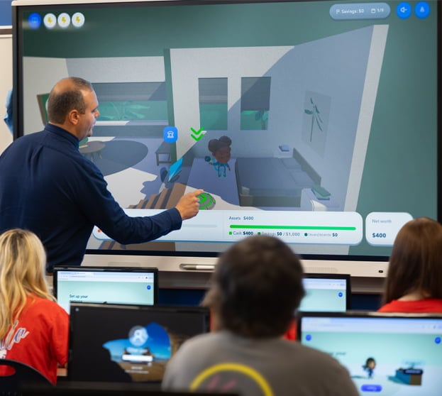 A group of people watching a computer screen.