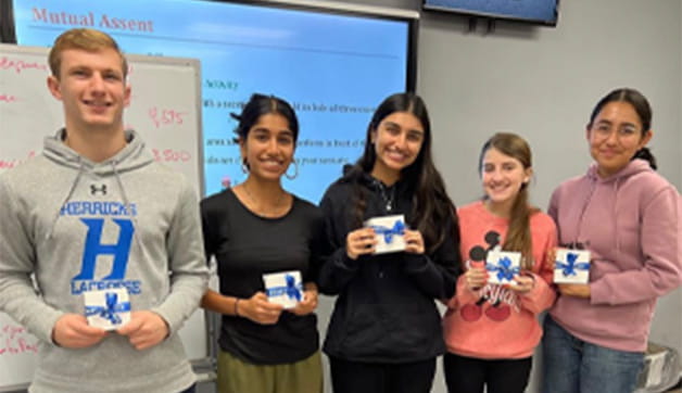 A group of students holding up gift boxes.