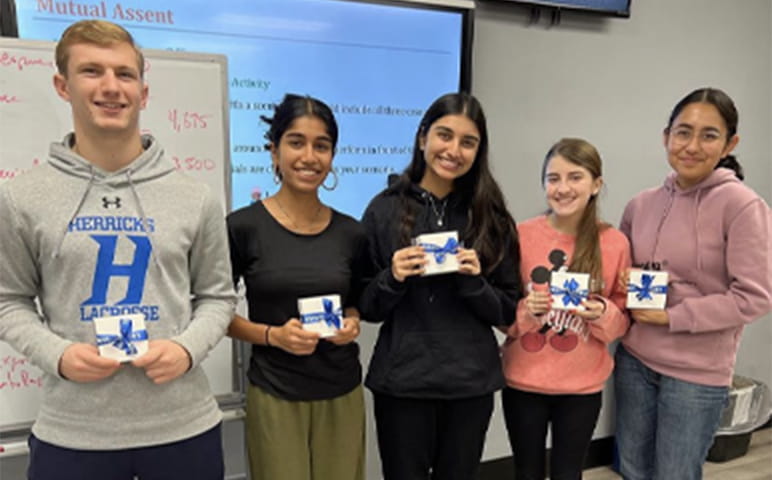 A group of students holding gift boxes in their hands.
