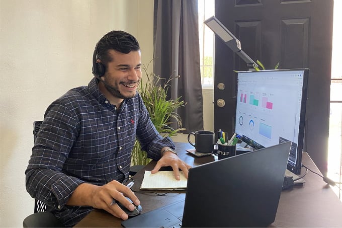 Employee smiling in front of computer