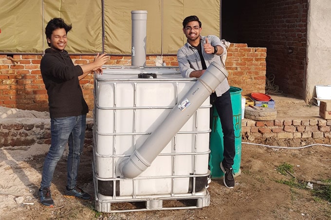 Two men smiling and leaning on an object