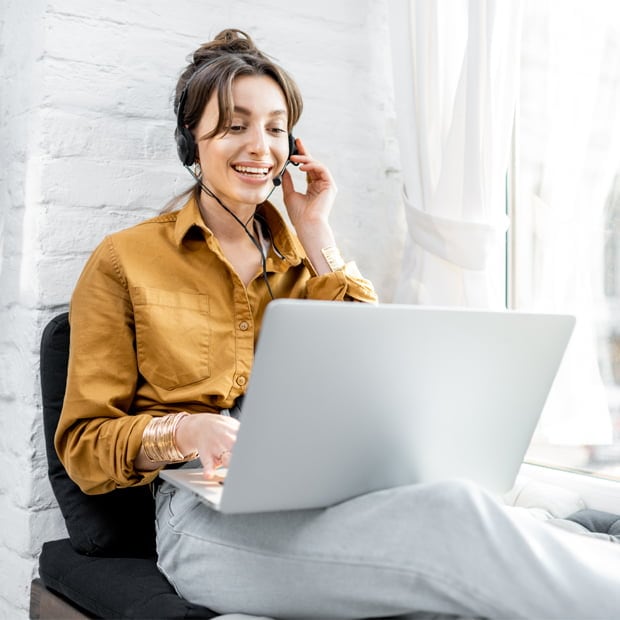 Woman with a headset working using a laptop