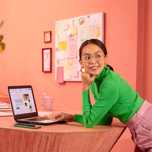 Woman leaning on a table using a laptop
