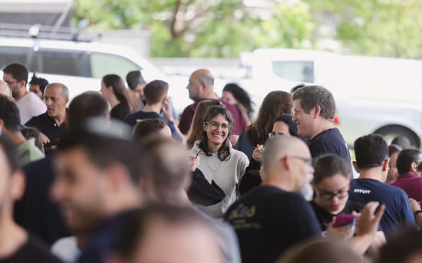 A crowd of people standing around each other.