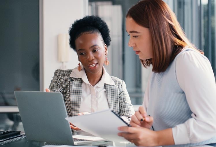 A photo of two business professionals reviewing cash pooling resources.