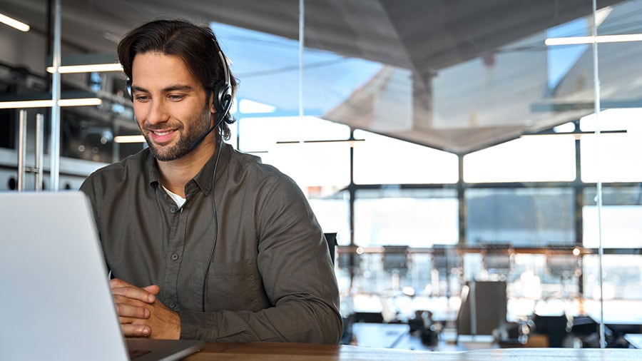A person sitting at a table talking on a cell phone.