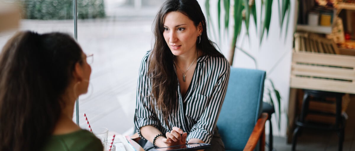 A person sitting at a table with a laptop.