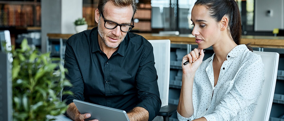 A person and person looking at a laptop computer.
