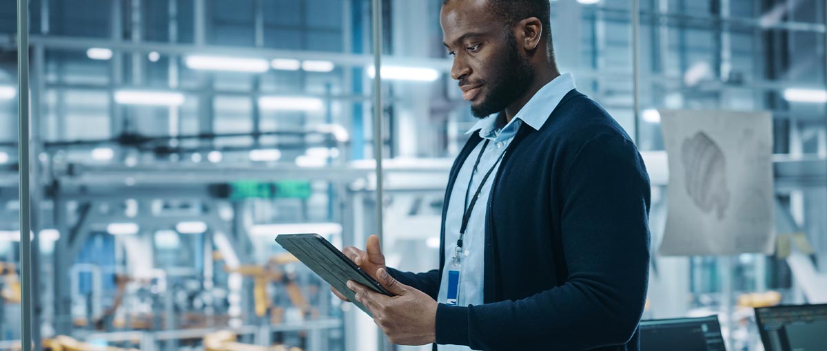 A person in a blue shirt holding a laptop.