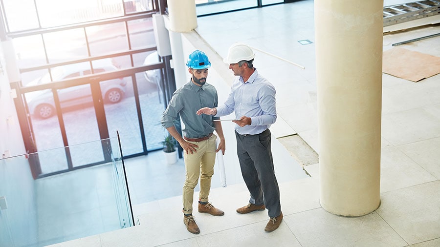 Two people in suits standing in a building.