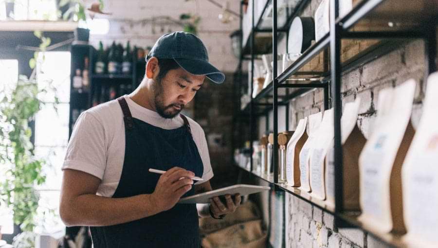 An image of a business owner taking inventory using a tablet, an example of a potential legacy ERP.