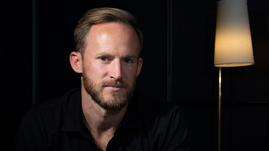 A person with a bald head wearing glasses and a shirt and tie.