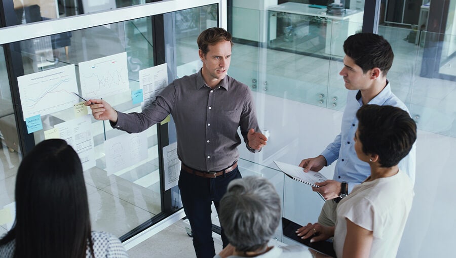 A group of people standing around a white table.